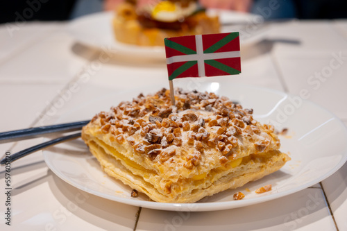 Basque Country food, sweet dessert, puff pastry cake with vanilla cream and hazelnut and flag of Basque Country, Spain photo