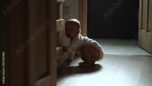 happy baby boy crawling on floor toddler exploring home curious infant having fun enjoying childhood. Little Cute smilling Child in white bodysuit try to stand up walk first steps barefoot on floor