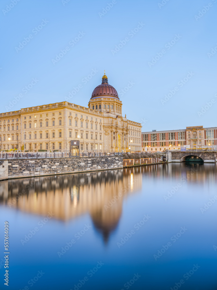 Berlin Humboldt Forum and its reflection on Spree canal surface at dusk, Germany
