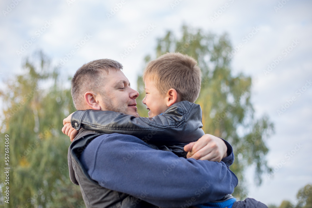 Happy father and son hugging and playing together in green nature. Fisherman's house with a wooden pedestrian bridge on a tiny island in the middle of the lake. Happy father and son hugging and playing together in green nature. Fisherman's house with a wooden pedestrian bridge on a tiny island in the middle of the lake.