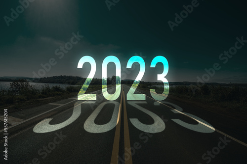 Happy New year 2023 with shadow effect of words in the background of road photo