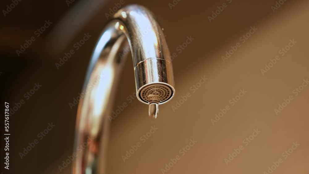 Tap faucet water turning off to a drip flu background. Drought, water infrastructure and resources. Symbolic of water running out and scarcity. Tap faucet water turning off to a drip flu background. Drought, water infrastructure and resources. Symbolic of water running out and scarcity.