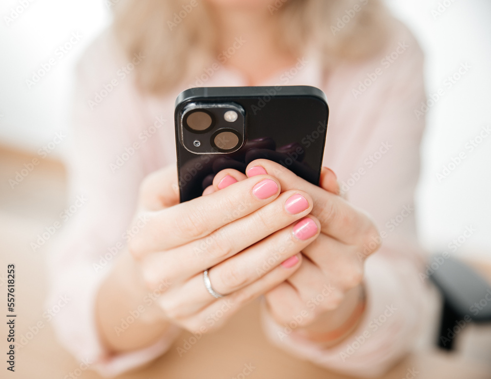 Front view of woman hand using mobile phone, work and communication concept, home office Front view of woman hand using mobile phone, work and communication concept, home office