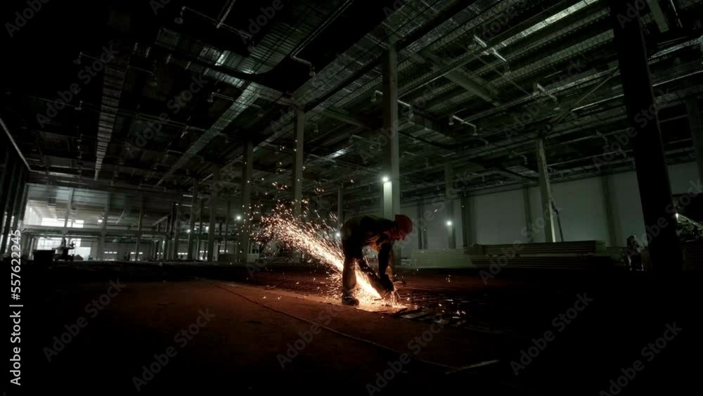 Industrial professional worker is cutting metal rebar with a circular saw. Construction of a factory, hangar Industrial professional worker is cutting metal rebar with a circular saw. Construction of a factory, hangar