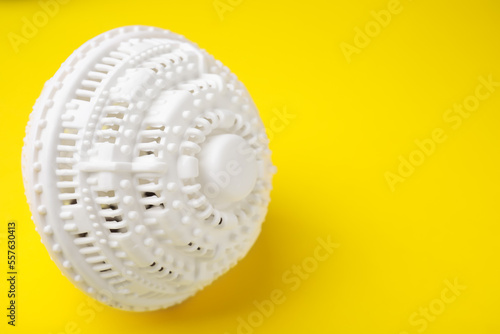 Laundry dryer ball on yellow background, space for text