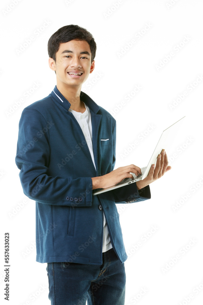 Young Asian teenage boy in casual clothes on a white background holding a laptop computer. Young Asian teenage boy in casual clothes on a white background holding a laptop computer.