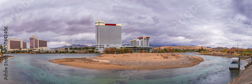 Colorado River Landscape Series, Laughlin skyline and buildings with dramatic stormy cloudscape over the curving river and sand island of a wildlife sanctuary in Laughlin, Nevada, USA photo