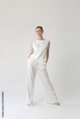 Tableau sur toile Serie of studio photos of young female model in all white silk outfit, sleeveles
