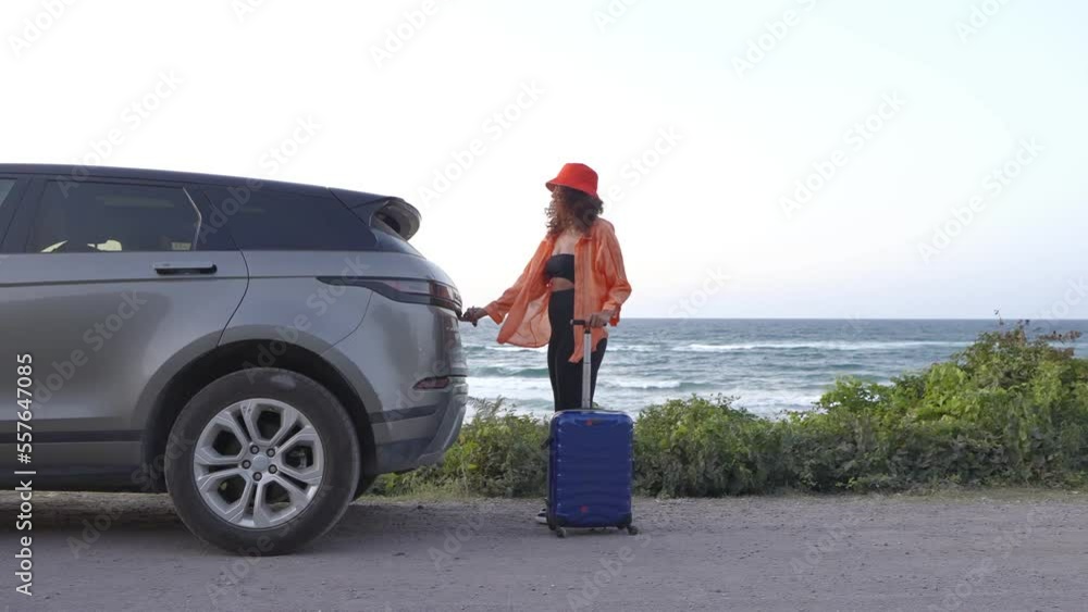 Slow Motion African American Young is opening luggage of auto. Ethnic happy woman putting suitcase inside of her auto. the female driver who wearing orange shirt and hat travel by private car. Slow Motion African American Young is opening luggage of auto. Ethnic happy woman putting suitcase inside of her auto. the female driver who wearing orange shirt and hat travel by private car.