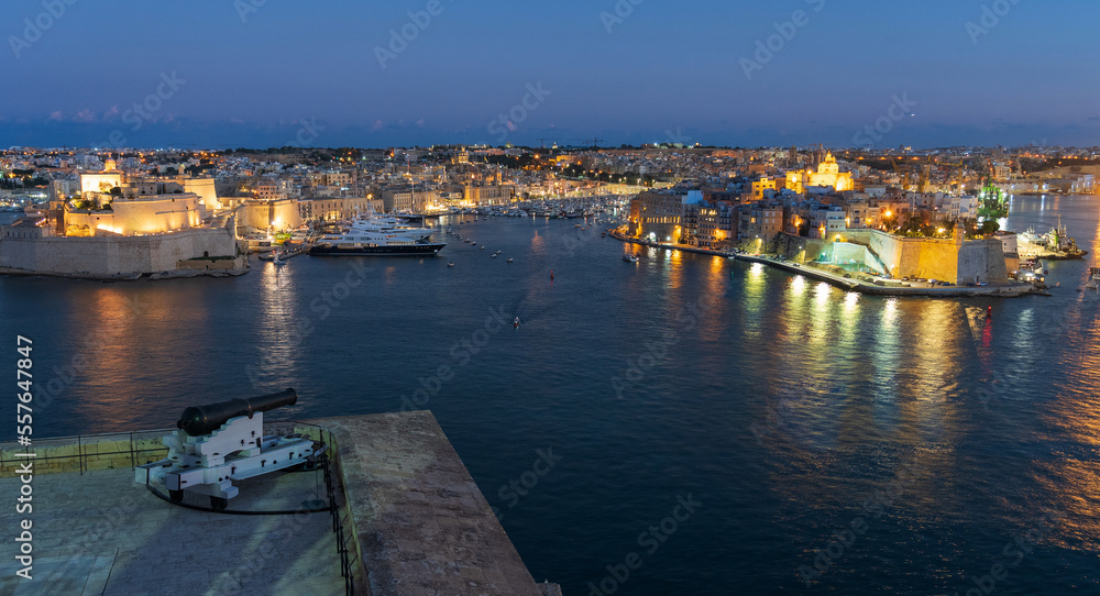 Valletta, Malta waterfront at night with a cannon from the Saluting Battery in foreground
