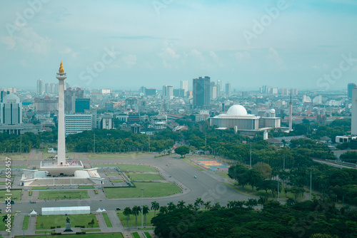 daytime view of the National Monument (Monas) next to the Istiqlal Mosque, photographed from the top of the National Library (Perpusnas) building Jakarta, Indonesia photo