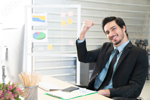 Portrait of businessman pushing his hand up to cheer up, business success concept photo