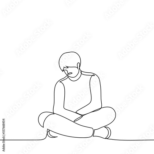 man is sitting on the floor with legs and arms crossed and head down - one line drawing vector. concept sad man sitting in a closed pose
