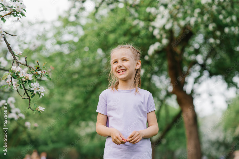 Cute girl laughs loudly outdoors, walking in the park in the spring Cute girl laughs loudly outdoors, walking in the park in the spring