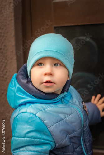 Close-up portrait of a little boy in a cap outdoors in early spring.
