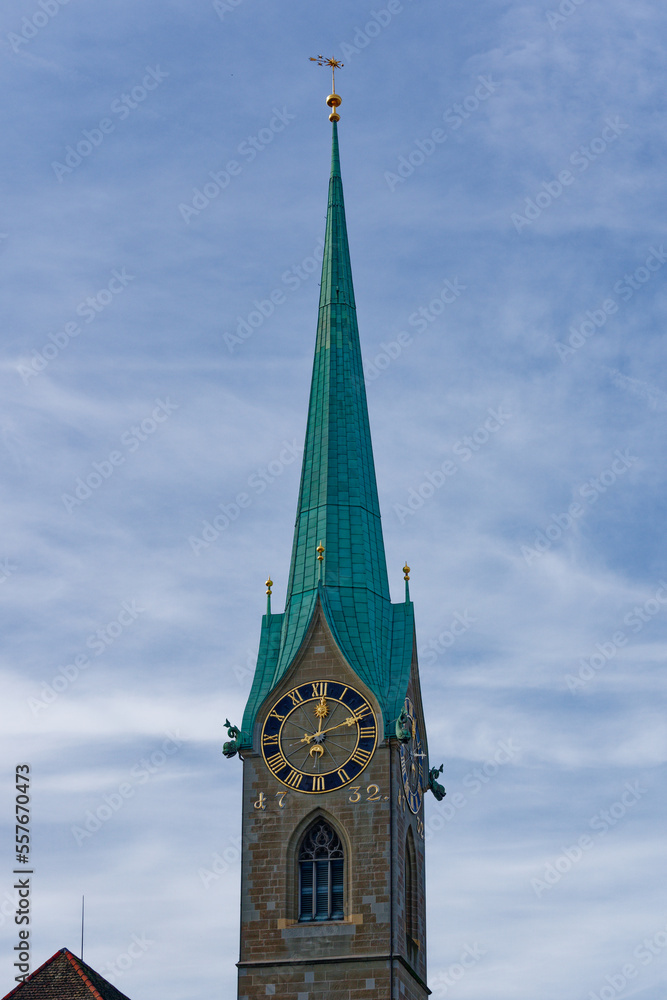 Church tower of famous church Women's Minster at the medieval old town of Zürich on a blue cloudy autumn day. Photo taken October 30th, 2022, Zurich, Switzerland.