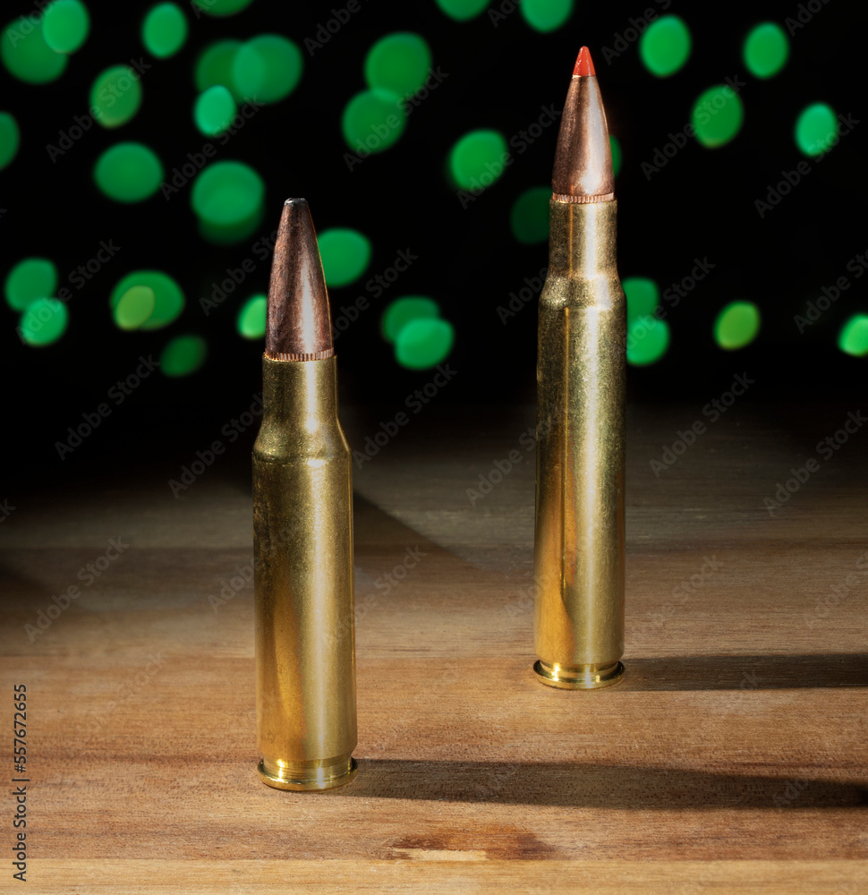 Large and smaller rifle ammo with Christmas lights behind Large and smaller rifle ammo with Christmas lights behind