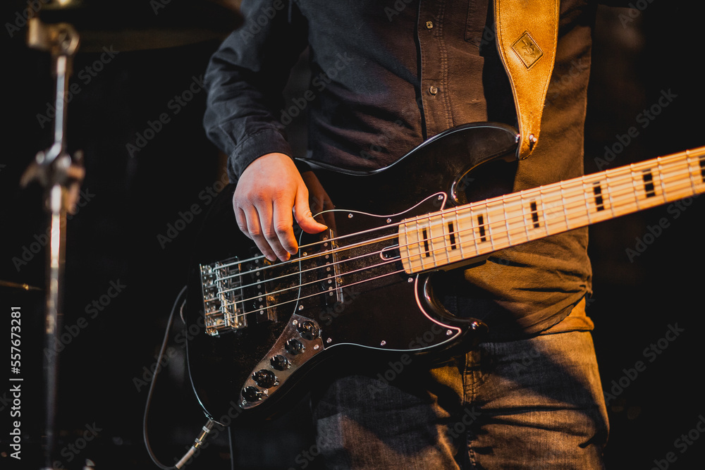 Obraz premium Man playing five string bass guitar with black shirt