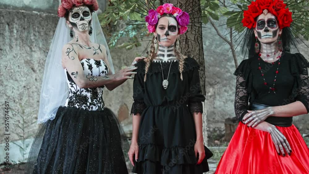 Slow motion Costume performance group portrait of three Women in the guise of Holy Death. Traditional Dia de Los Muertos Festival in Mexico Slow motion Costume performance group portrait of three Women in the guise of Holy Death. Traditional Dia de Los Muertos Festival in Mexico