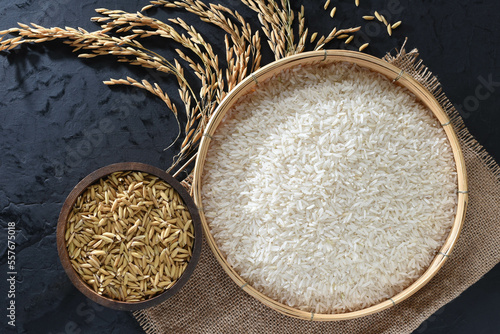 Obraz na płótnie Paddy and rice in baskets placed on a black background with ears of rice. w salonie