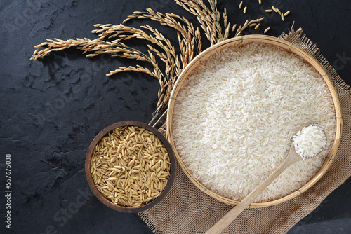 Obraz na płótnie Paddy and rice in baskets placed on a black background with ears of rice. w salonie