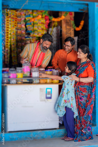 Indian little girl child purchasing some item with his mother at grocery store © Niks Ads