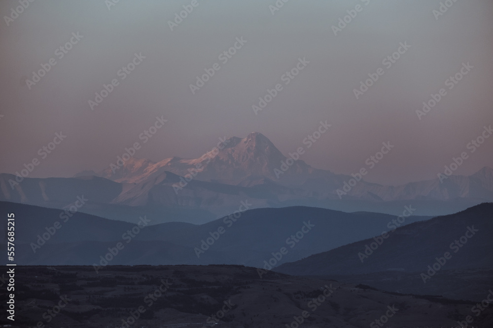 Fototapeta premium Silhouette of Mount Kazbek in Caucasian mountains view from Tbilisi