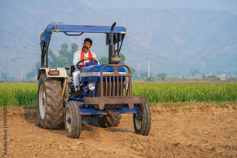 Obraz premium Indian farmer working with tractor at field.