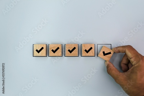 hand arranging or placing the correct marks in order. the concept of approving documents and project concepts. the concept of a checklist or check mark photo