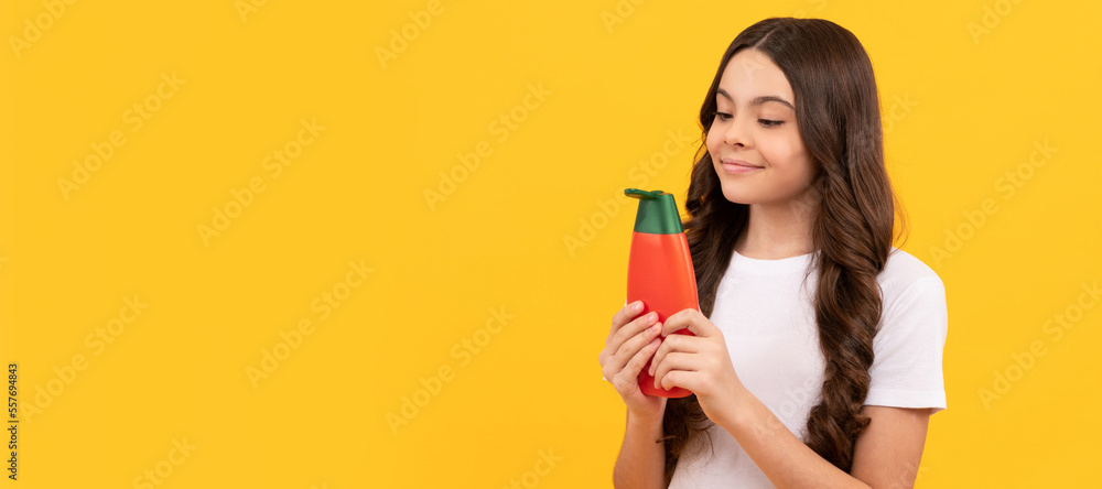 presenting cosmetic product for teen. kid with shower gel. happy girl hold shampoo bottle. Banner of child girl hair care, studio poster header with copy space. presenting cosmetic product for teen. kid with shower gel. happy girl hold shampoo bottle. Banner of child girl hair care, studio poster header with copy space.