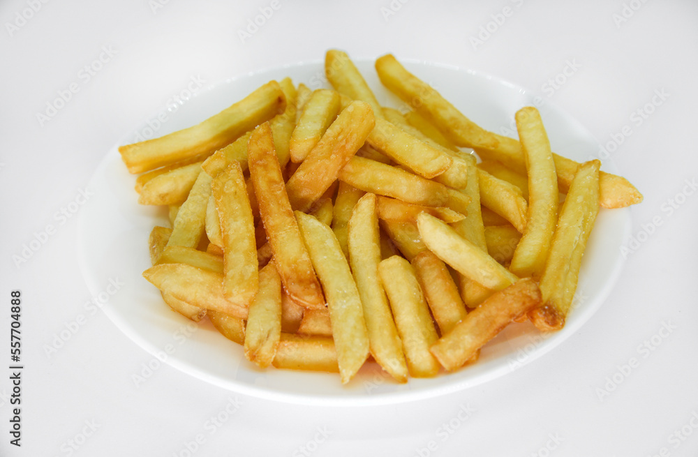 Yellow delicious French fries in white dishes. Fast food on a plate. Fried potatoes. Toasted potato slices on a white background. Yellow delicious French fries in white dishes. Fast food on a plate. Fried potatoes. Toasted potato slices on a white background.