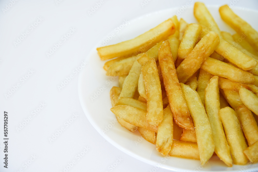 Yellow delicious French fries in white dishes. Fast food on a plate. Fried potatoes. Toasted potato slices on a white background. Yellow delicious French fries in white dishes. Fast food on a plate. Fried potatoes. Toasted potato slices on a white background.