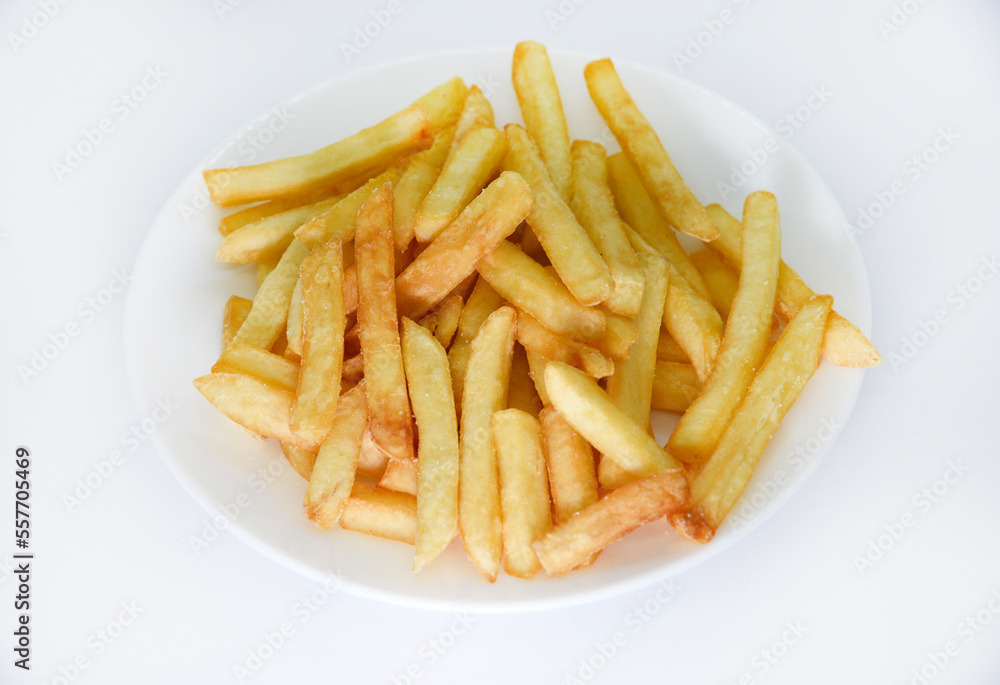 Yellow delicious French fries in white dishes. Fast food on a plate. Fried potatoes. Toasted potato slices on a white background. Yellow delicious French fries in white dishes. Fast food on a plate. Fried potatoes. Toasted potato slices on a white background.