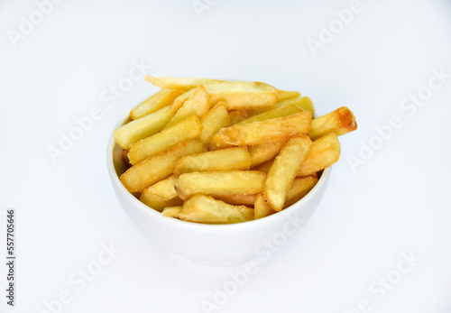 Yellow delicious French fries in white dishes. Fast food on a plate. Fried potatoes. Toasted potato slices on a white background.