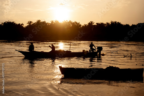 silhouette of fishermen with boats at dawn