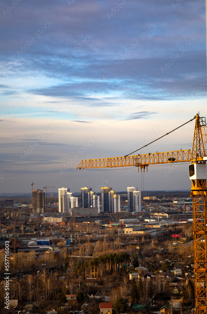 Naklejka premium Inside place for many tall buildings under construction and cranes under a blue sky