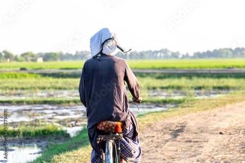 old farmer traveling on a cycle between fields