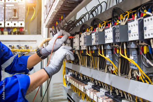 Electricity or electrical maintenance service, Engineer hand checking electric current voltage at circuit breaker terminal and cable wiring check in main power load center distribution board. photo