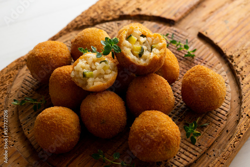 Arancini are a specialty of Sicilian cuisine. They are stuffed breaded and fried rice balls or cones.