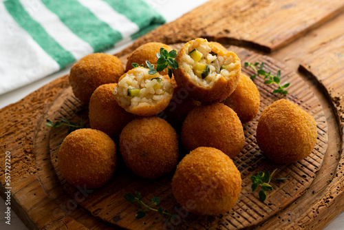 Arancini are a specialty of Sicilian cuisine. They are stuffed breaded and fried rice balls or cones.