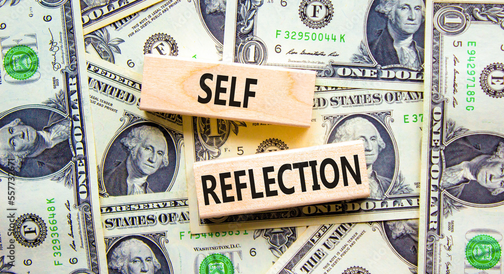 Self reflection symbol. Concept word Self reflection typed on wooden blocks. Beautiful background from dollar bills. Business psychological and self reflection concept. Copy space.