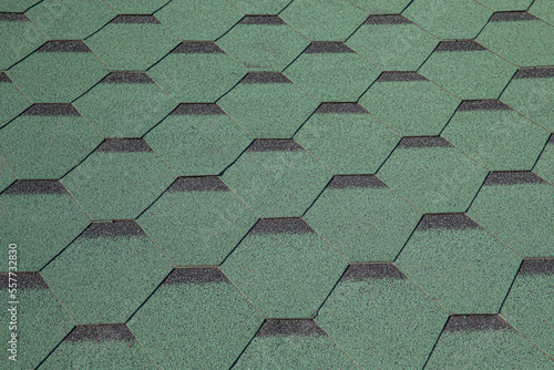 Roofing made of green soft bitumen tiles on a hipped roof of a house. Close up view of Asphalt Roofing green Tile Background. Green tiles on the roof of the house. Roof Shingles, Roofing Repair. photo