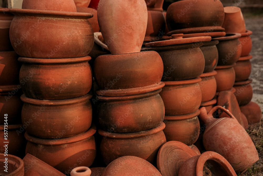 Stacks of handmade ceramic red clay brick pots for plants in a greenhouse or for cooking 2 Stacks of handmade ceramic red clay brick pots for plants in a greenhouse or for cooking 2
