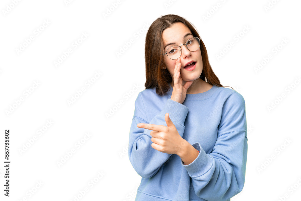 Teenager girl over isolated chroma key background pointing to the side to present a product and whispering something Teenager girl over isolated chroma key background pointing to the side to present a product and whispering something