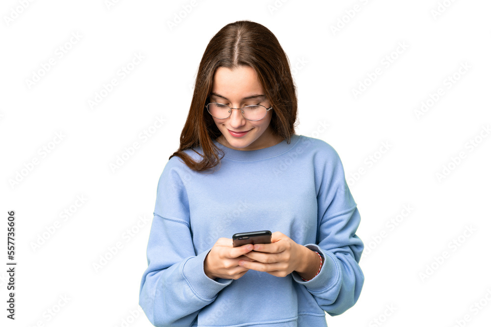 Teenager girl over isolated chroma key background sending a message with the mobile Teenager girl over isolated chroma key background sending a message with the mobile