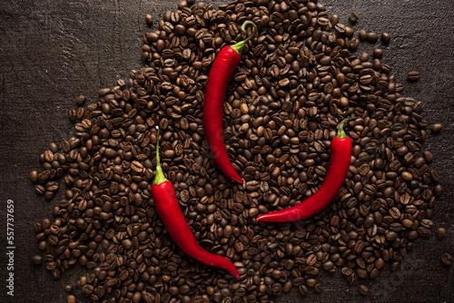 aromatic coffee beans with bitter hot chili pepper on a black background