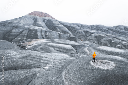 Anonymous backshot orange jacket adventurer in cold tundra