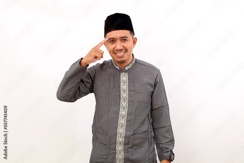 Smart asian muslim man standing while pointing his head to thinking something. Isolated on white background Smart asian muslim man standing while pointing his head to thinking something. Isolated on white background