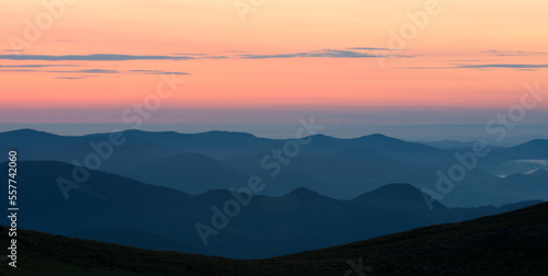 Silhouettes of mountains. Panoramic view of mountain peaks at dawn.