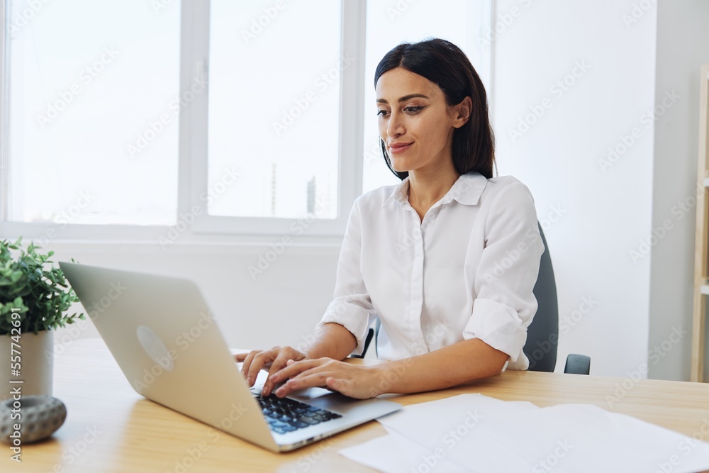 Woman business works at her laptop at home in her office, freelance employee in business, happiness of working online, technology in business smile